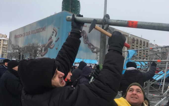 В центре Киева участники марша Руху новых сил разбирают металлические конструкции